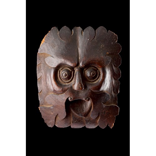 A Powerful Carved ‘Green Man’ with Piercing Eyes and Protruding Tongue